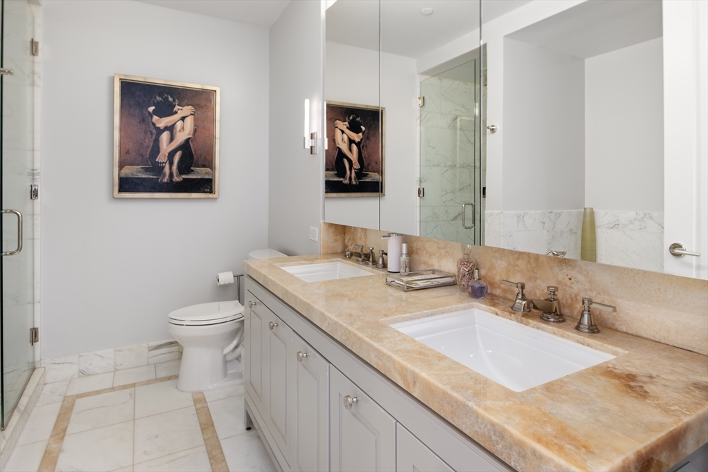 400 Stuart Street, Unit 17B Boston, MA 02116 - Photo 8 of 12 a bathroom with a granite countertop sink and a mirror