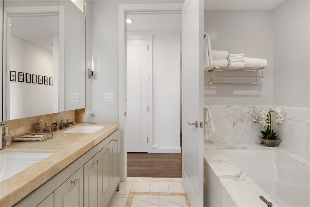 400 Stuart Street, Unit 17B Boston, MA 02116 - Photo 9 of 12 a bathroom with a tub sink and mirror