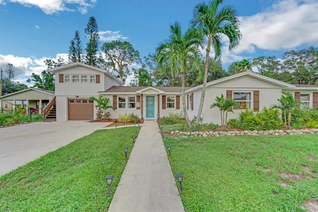 a front view of a house with a yard and potted plants