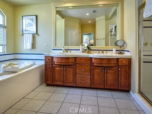 a spacious bathroom with a granite countertop tub sink and mirror