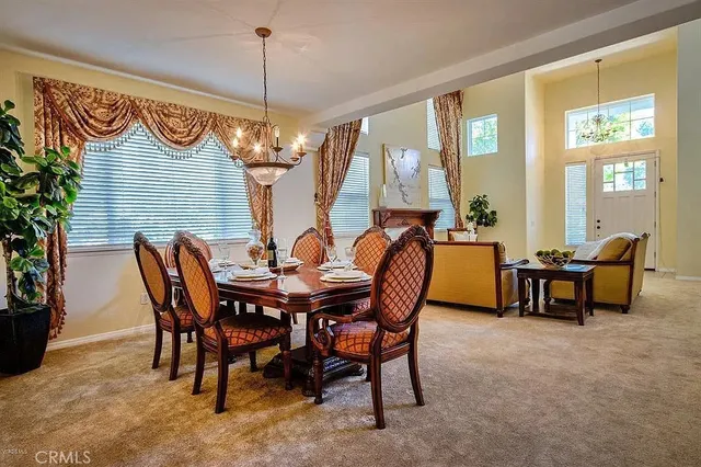 a view of a dining room and livingroom with furniture wooden floor a chandelier
