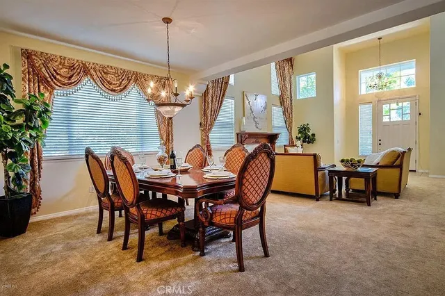 a view of a dining room and livingroom with furniture wooden floor a chandelier
