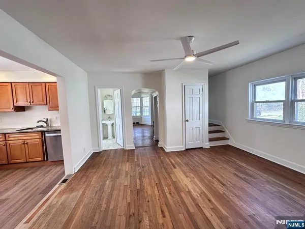a view of an empty room with window and wooden floor