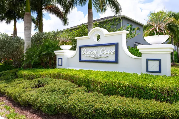 a view of sign board and palm trees