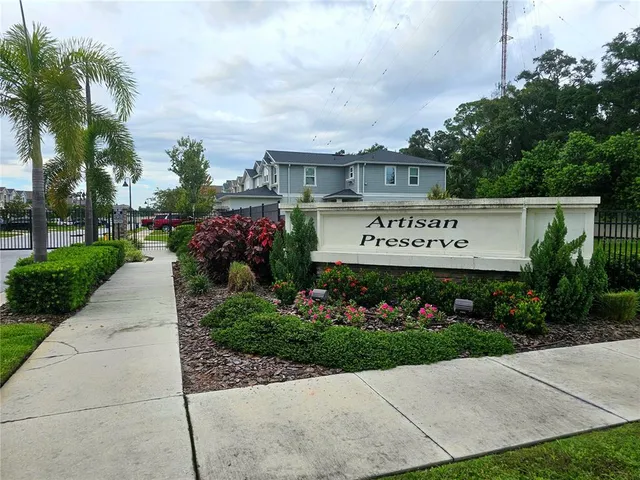 a front view of a house with a yard and potted plants