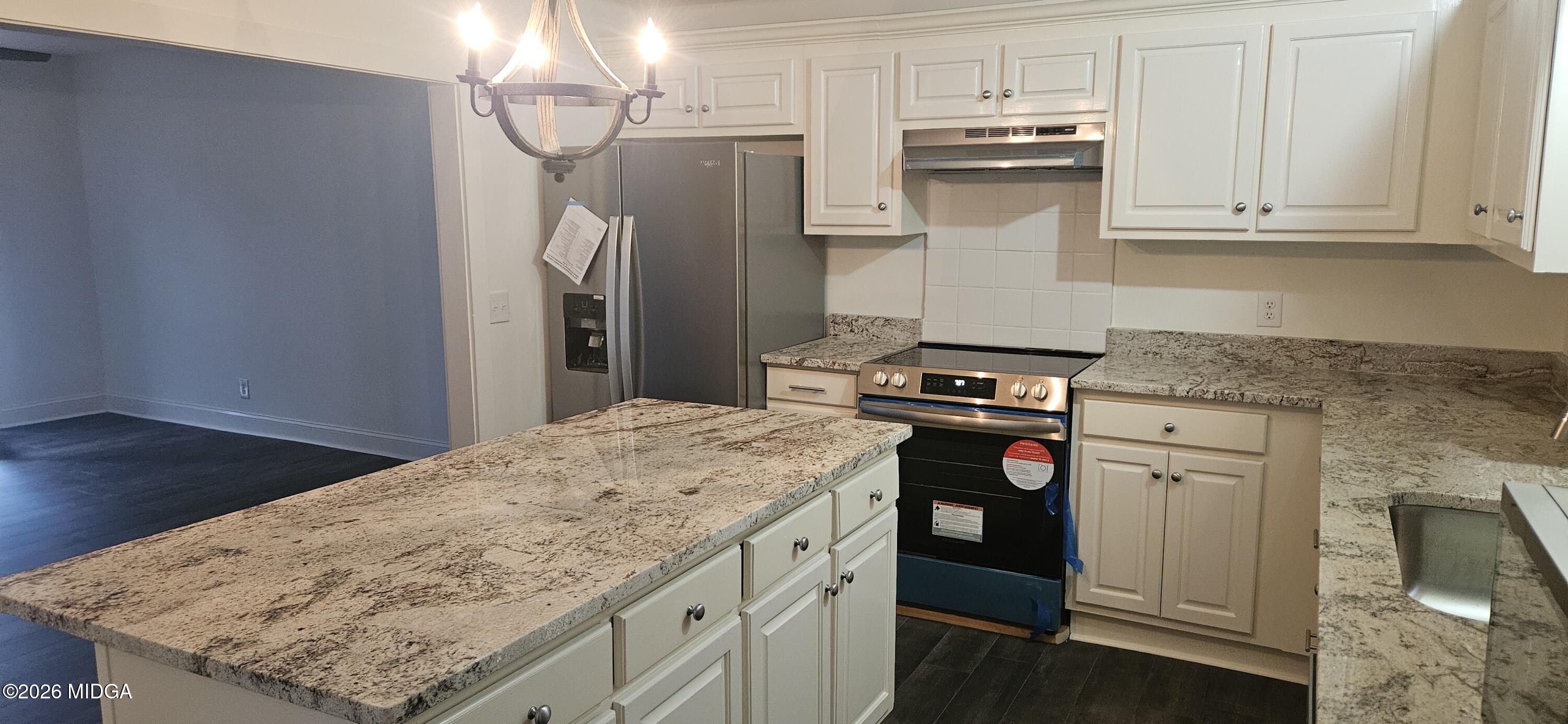 29 Dolly Lane Macon, GA 31217 - Photo 7 of 16 a kitchen with stainless steel appliances granite countertop a stove and a refrigerator
