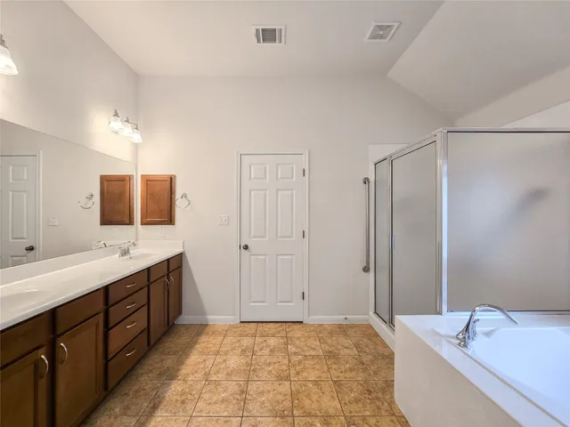 a bathroom with a tub sink and mirror