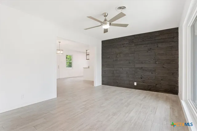 an empty room with closet and fan