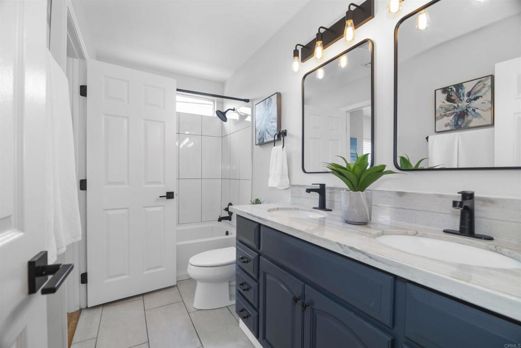 178 Elder Avenue Imperial Beach, CA 91932 - Photo 15 of 26 a bathroom with a granite countertop sink a toilet a mirror and shower