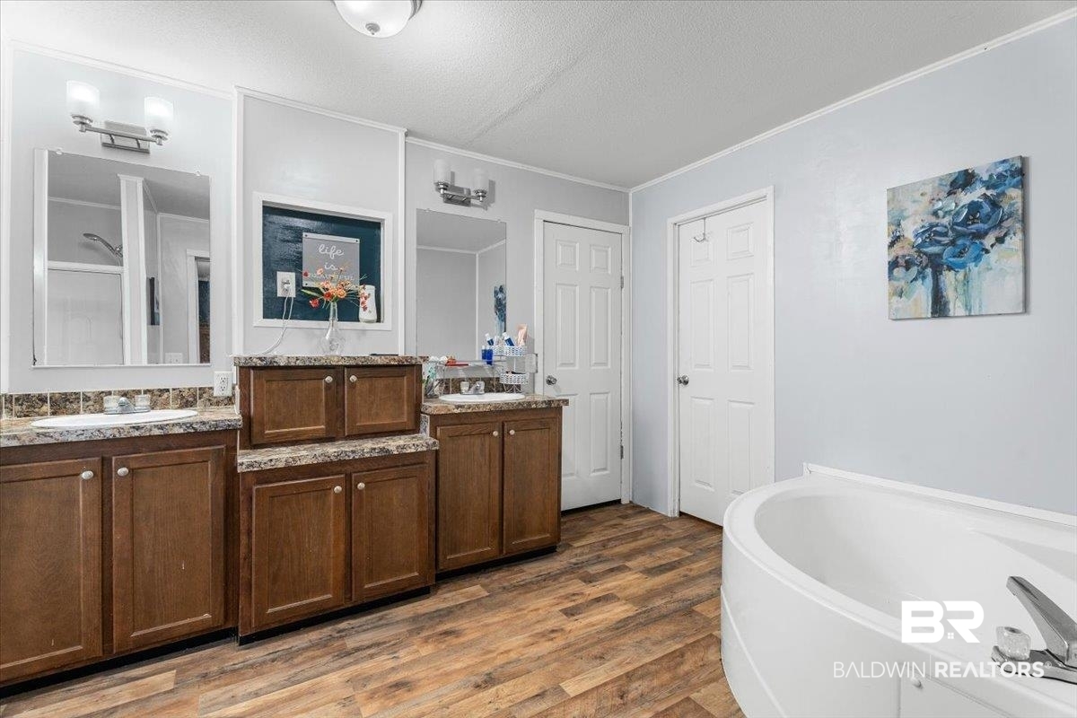 21011 River Road Robertsdale, AL 36567 - Photo 13 of 29 Bathroom featuring a dual vanity with wood-finish cabinetry, integrated sinks, and coordinating countertops
