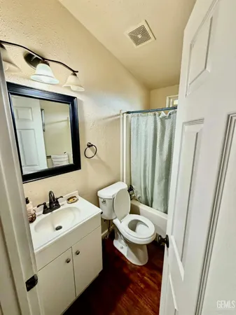 a bathroom with a toilet sink and mirror