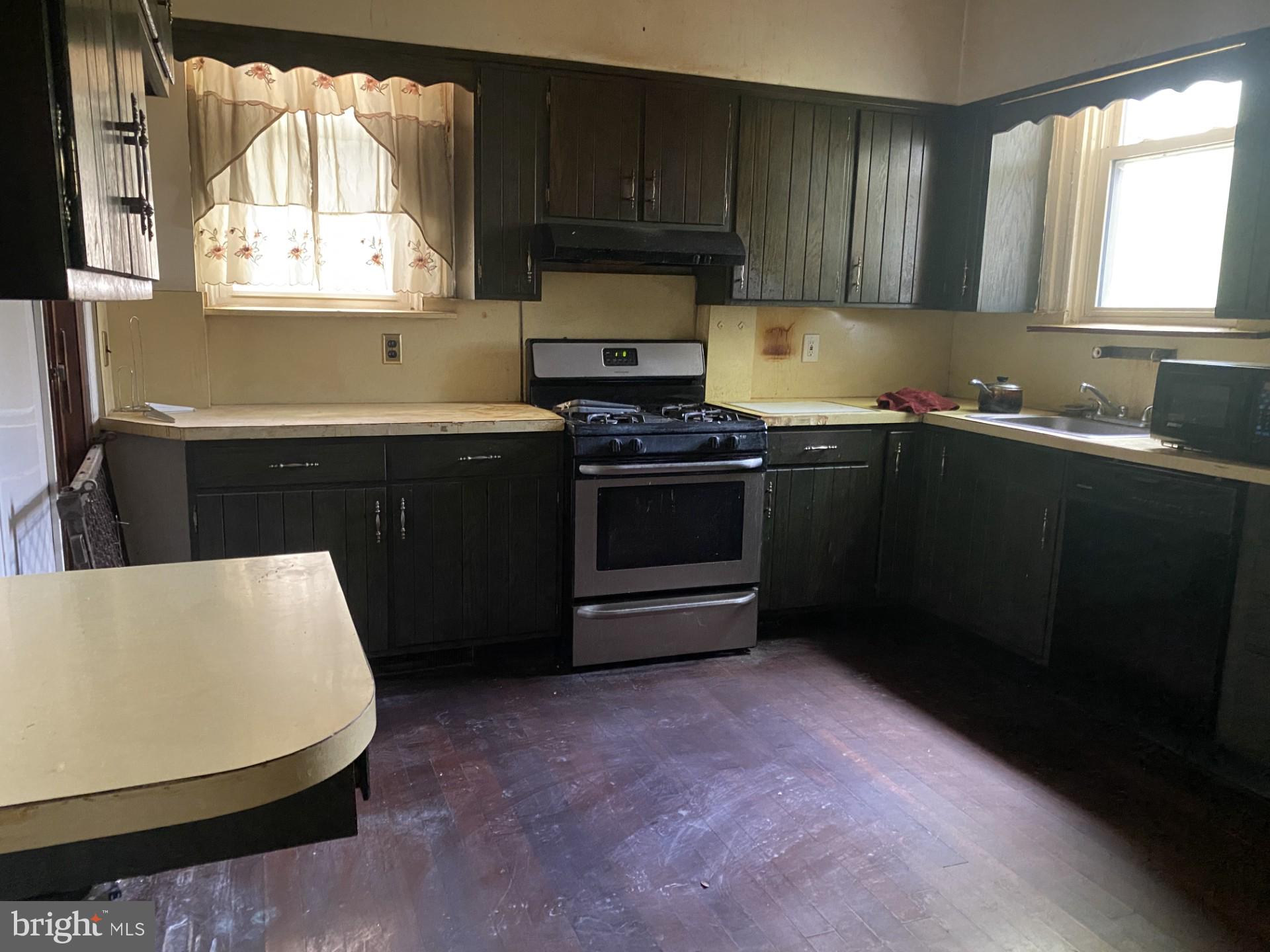 2802 Mosher Street Baltimore, MD 21216 - Photo 3 of 6 a kitchen with granite countertop a stove a sink and a microwave