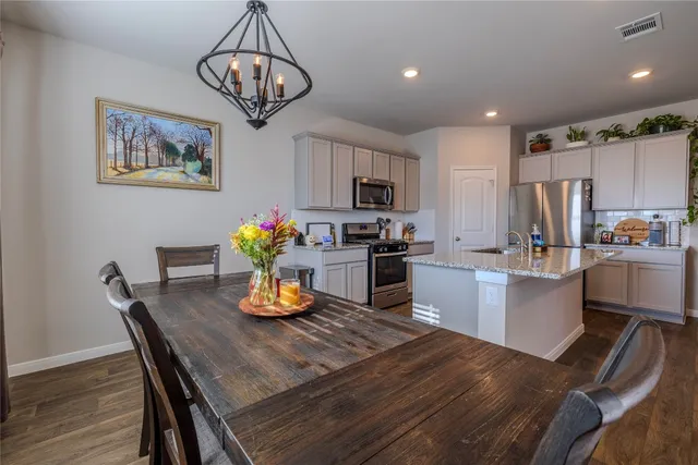 a kitchen with granite countertop stainless steel appliances a refrigerator and cabinets