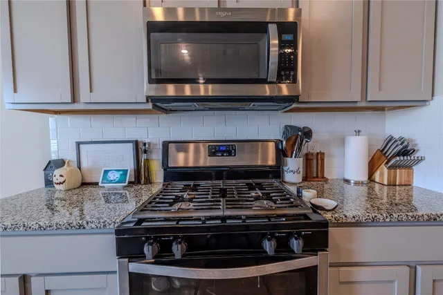 a kitchen with stainless steel appliances granite countertop a sink and a refrigerator
