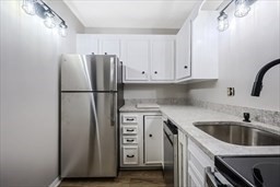 30 High Street, Unit 209 Dedham, MA 02026 - Photo 12 of 28 a kitchen with stainless steel appliances granite countertop a refrigerator sink and cabinets