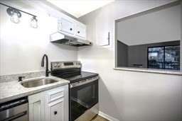 30 High Street, Unit 209 Dedham, MA 02026 - Photo 13 of 28 a kitchen with stainless steel appliances granite countertop a sink and a stove