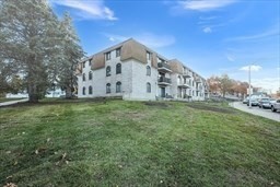 30 High Street, Unit 209 Dedham, MA 02026 - Photo 27 of 28 a view of a white house with a big yard and large trees