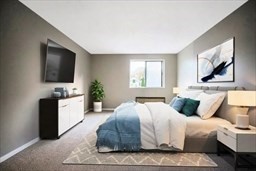 30 High Street, Unit 209 Dedham, MA 02026 - Photo 3 of 28 a bedroom with a large bed and a flat screen tv