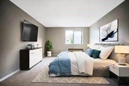 30 High Street, Unit 209 Dedham, MA 02026 - Photo 5 of 28 a bedroom with a large bed and a flat screen tv