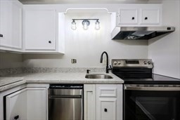 30 High Street, Unit 209 Dedham, MA 02026 - Photo 10 of 28 a kitchen with stainless steel appliances granite countertop a sink dishwasher a stove and white cabinets