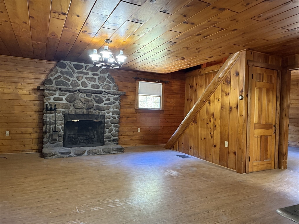 217 Nichols Road Barre, MA 01005 - Photo 20 of 41 a view of an empty room with wooden floor a fireplace and windows