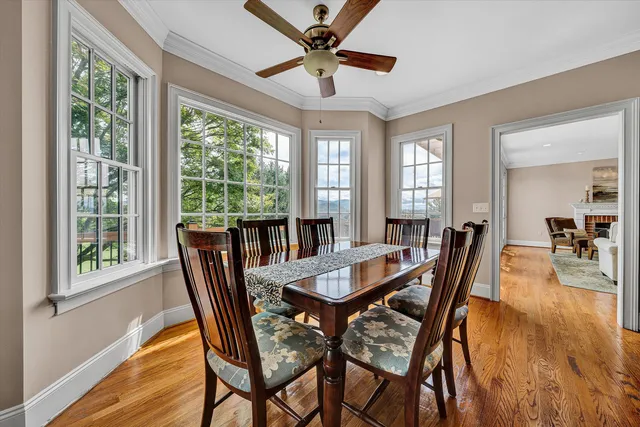 a view of a hallway with wooden floor and dining room