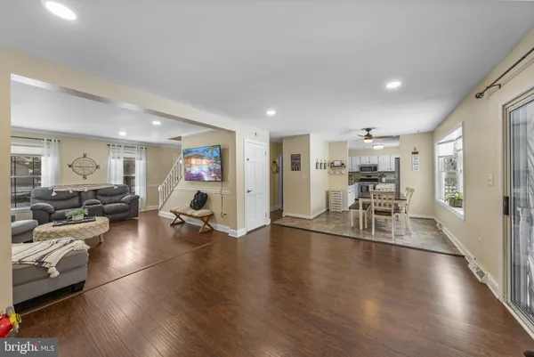 a view of a dining room and livingroom with furniture wooden floor a rug a fireplace