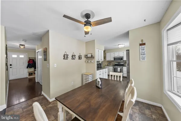 a kitchen with stainless steel appliances granite countertop a stove top oven a sink dishwasher a refrigerator and cabinets with wooden floor