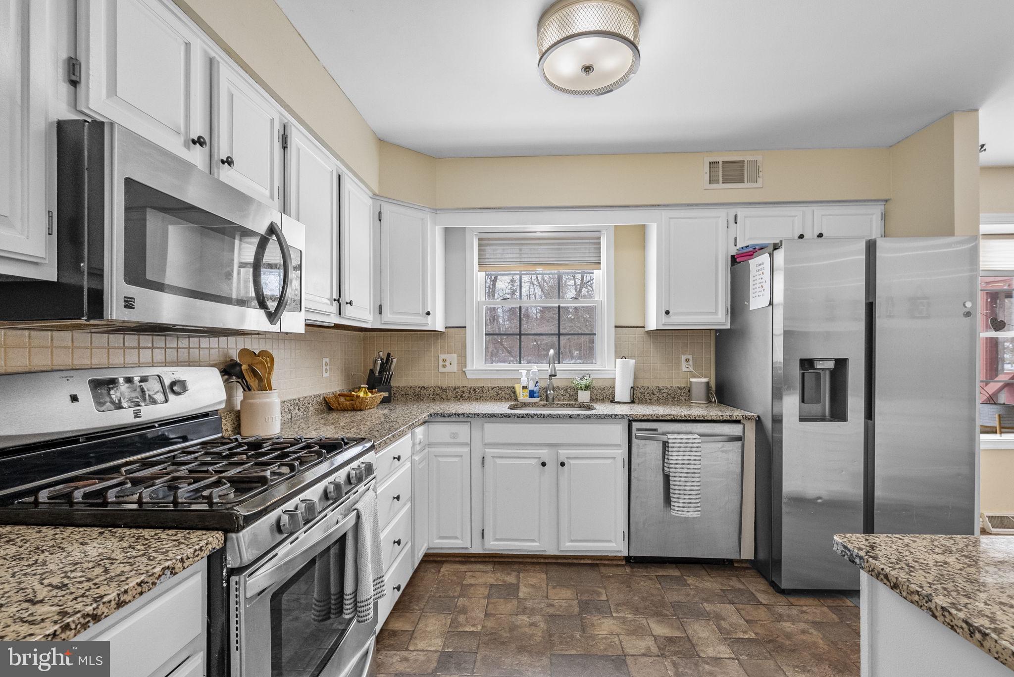 4 Birch Run Court Ewing, NJ 08628 - Photo 21 of 57 a kitchen with stainless steel appliances granite countertop a stove top oven a sink dishwasher a refrigerator and cabinets with wooden floor