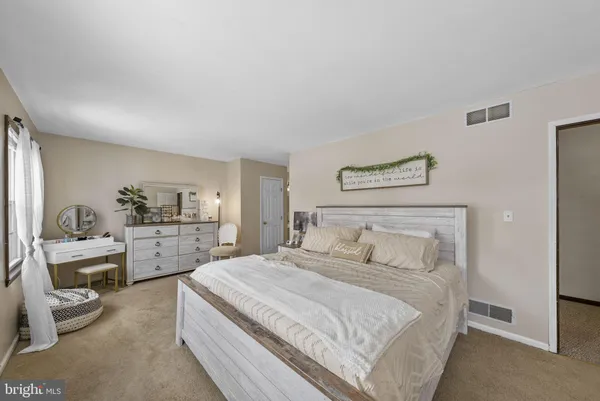 a bedroom with bed and large windows