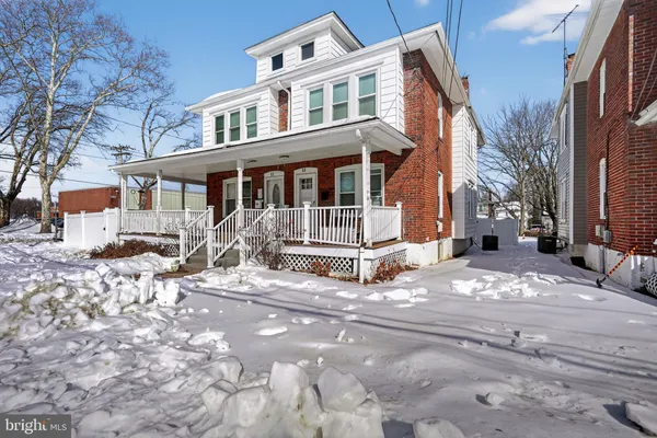 a view of a house with a yard covered in snow