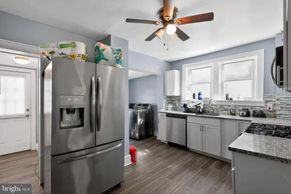 a kitchen with granite countertop a refrigerator stove and sink