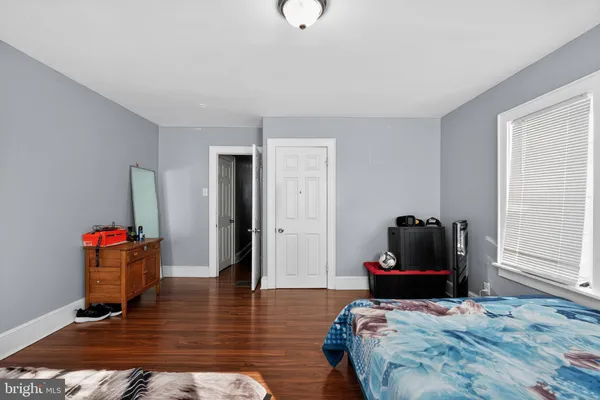 a bedroom with bed and wooden floor