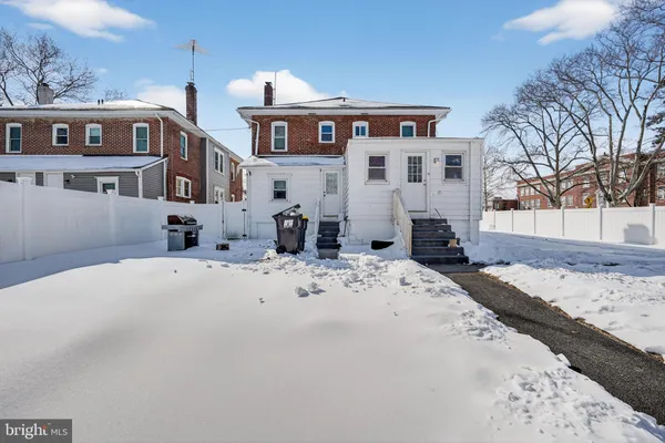 a view of a white house with a snow on the road