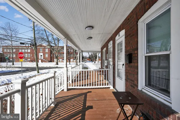 a view of a porch with wooden floor and iron stairs