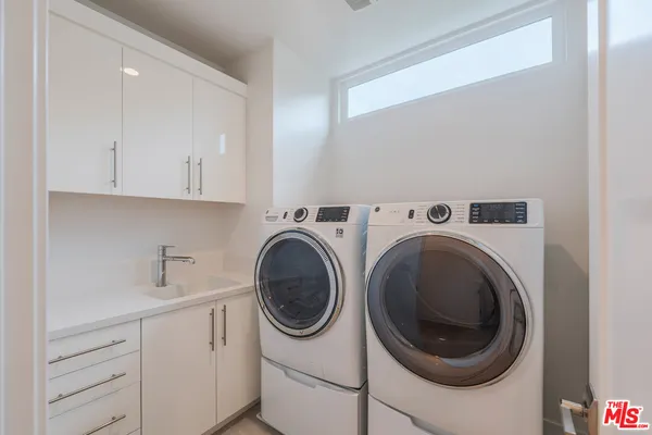 a utility room with sink dryer and washer