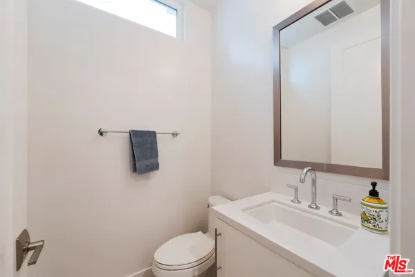a bathroom with a sink a toilet and mirror