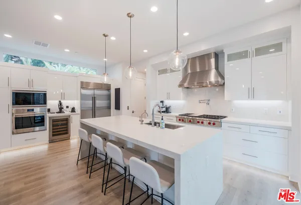a kitchen with kitchen island a stove a table and chairs in it