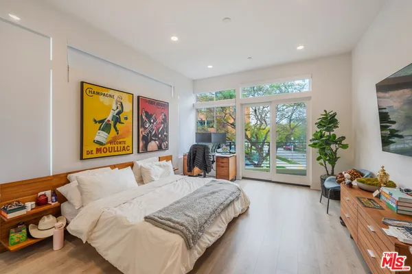 a bedroom with a bed and a large window