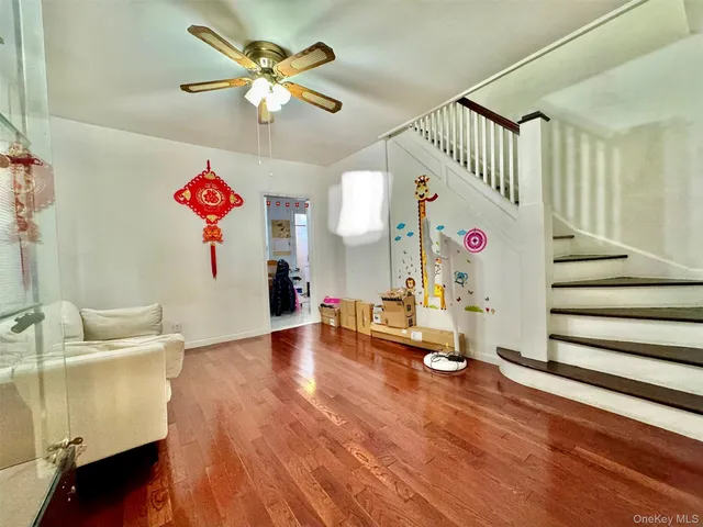 a living room with wooden floor and white walls