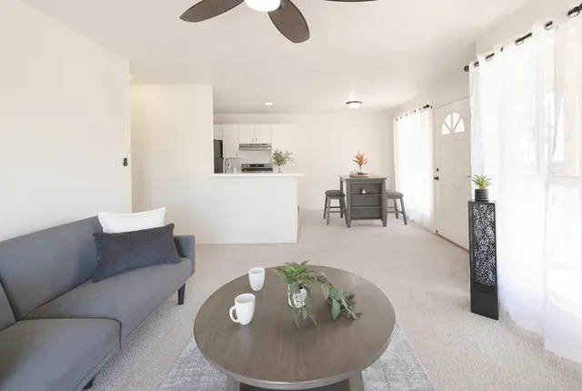 a living room with furniture and a dining table