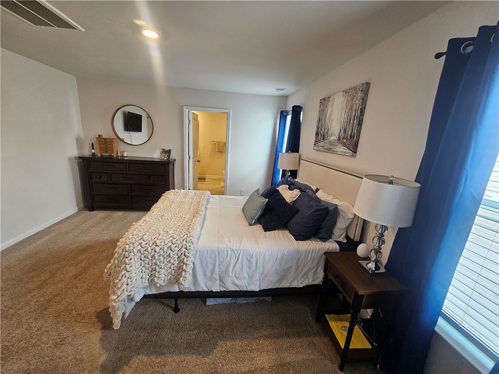 902 Ashwood Lane Easley, SC 29640 - Photo 20 of 39 A tranquil primary bedroom with plush carpeting and a convenient doorway to the en-suite bathroom.