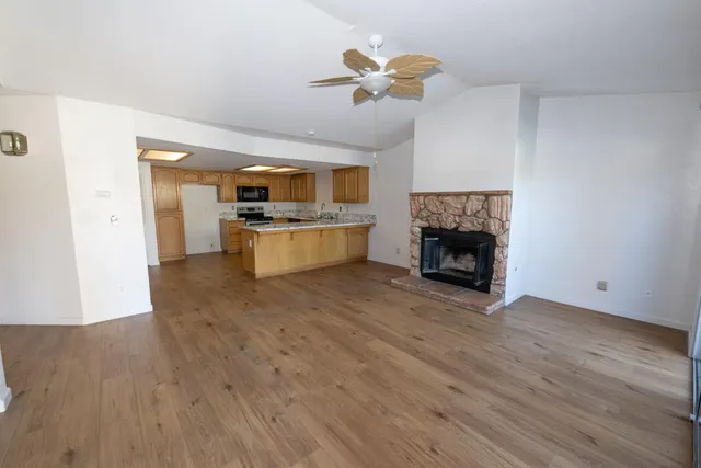 a view of empty room with wooden floor and fireplace