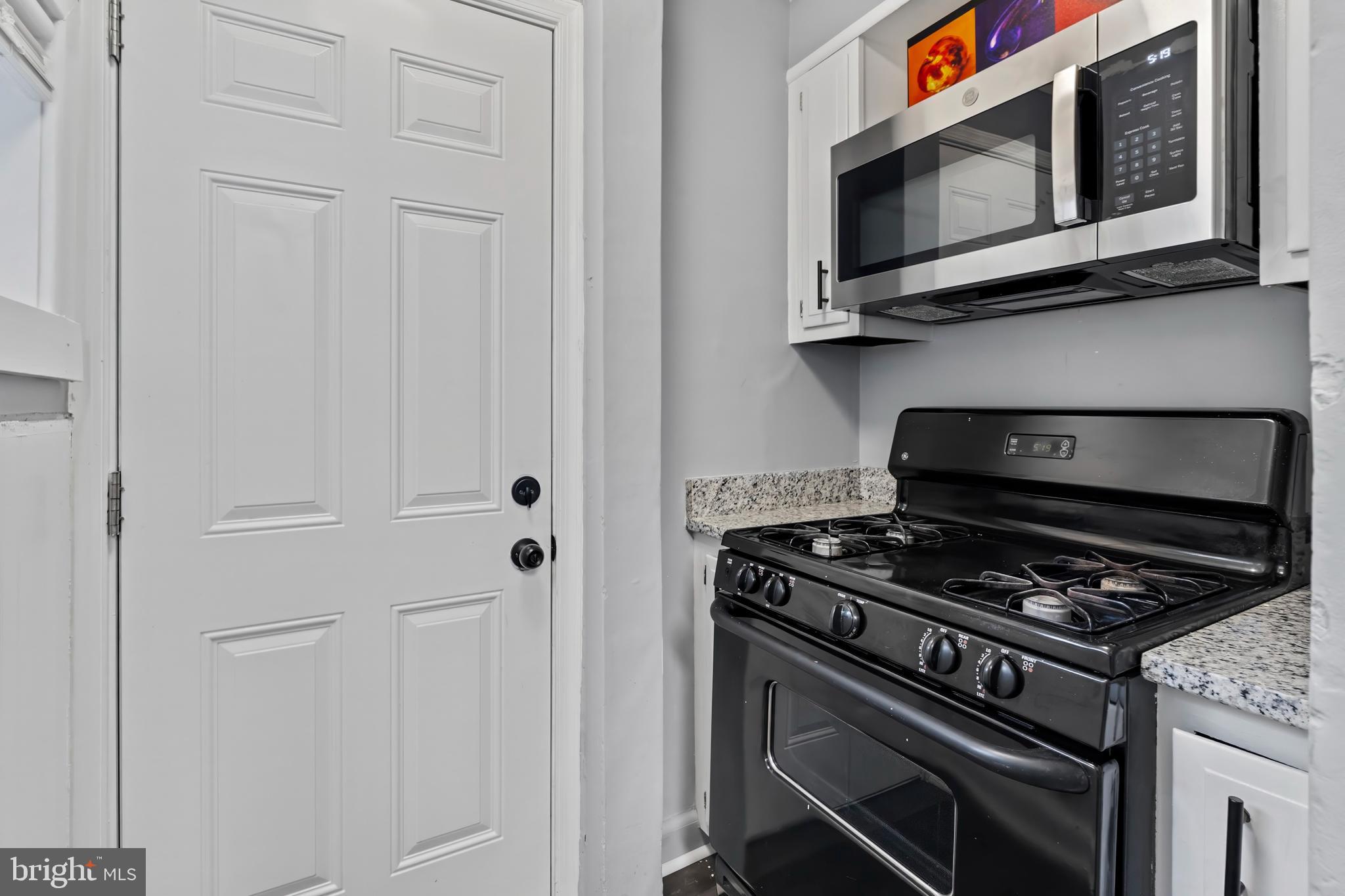 55 Kinship Road Baltimore, MD 21222 - Photo 17 of 42 a kitchen with stainless steel appliances granite countertop white cabinets and a stove