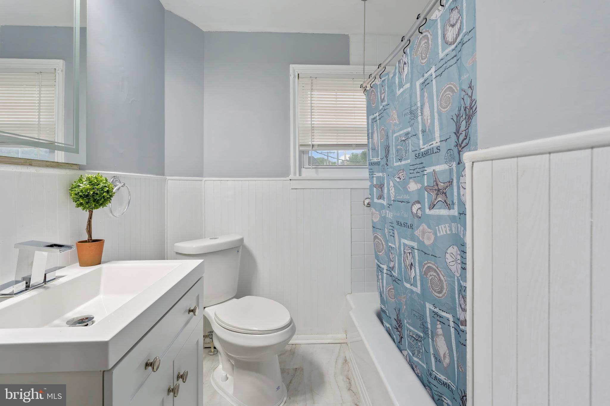 55 Kinship Road Baltimore, MD 21222 - Photo 18 of 42 a bathroom with a sink a toilet and shower curtain