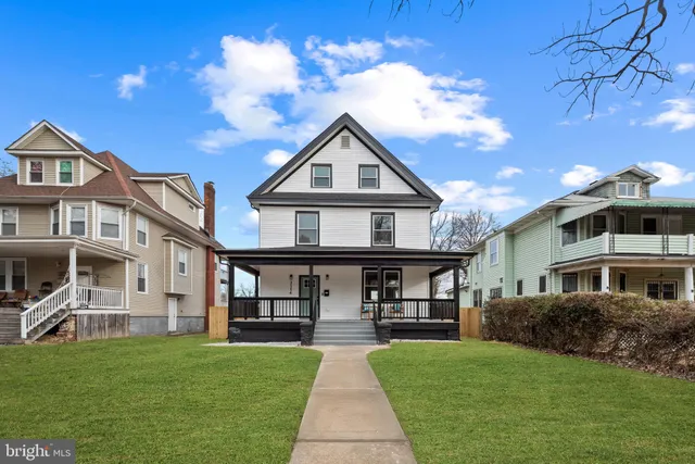 a front view of a house with yard and green space