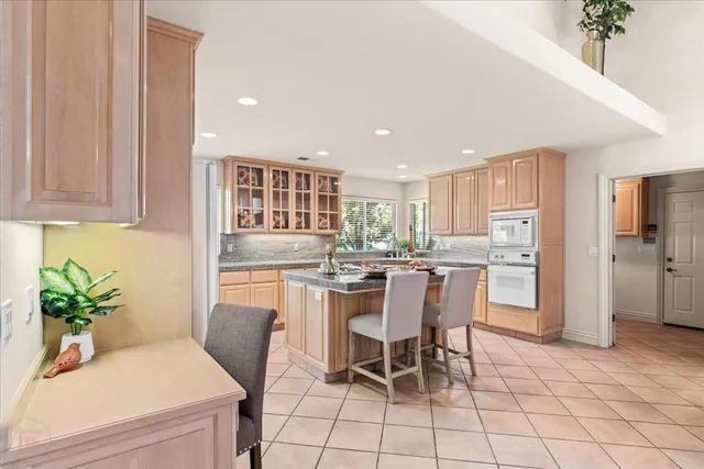 a kitchen that has a lot of white cabinets and stainless steel appliances