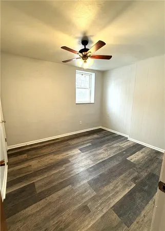 an empty room with a window and a ceiling fan