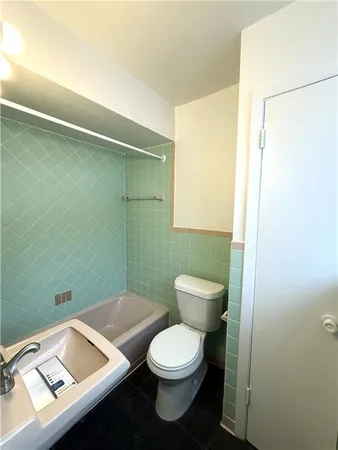 a bathroom with a toilet a sink and mirror