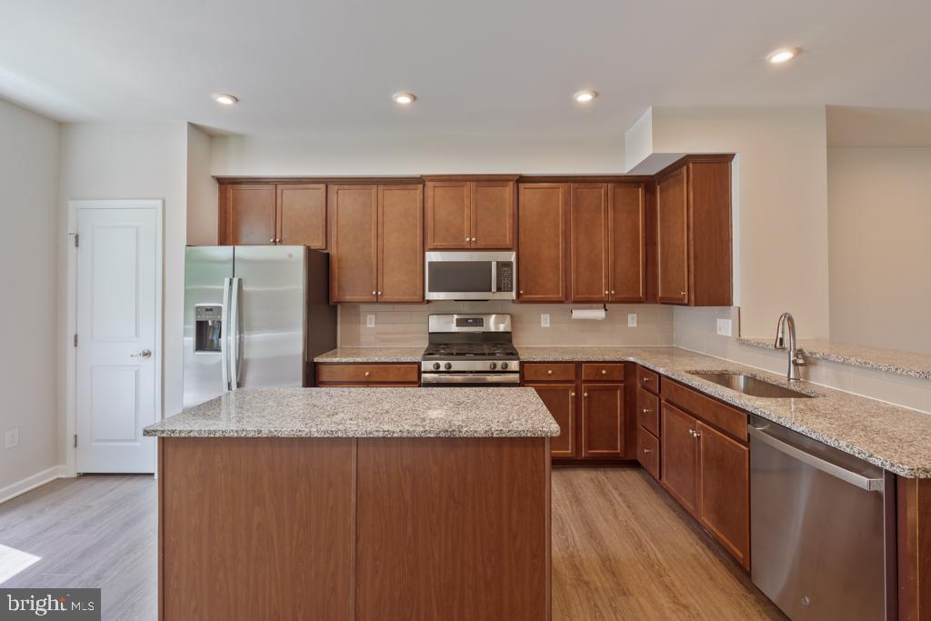 39 Sidney Lane Stratford, NJ 08084 - Photo 8 of 21 a kitchen with stainless steel appliances granite countertop a refrigerator a sink a stove a microwave and wooden cabinets